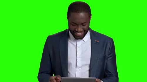 Homme afro-américain souriant avec tablette numérique.