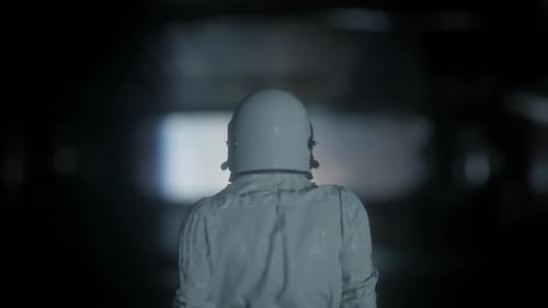 Astronaut Walking Through Dark Futuristic Tunnel Scene