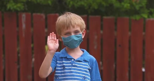 Boy Wearing a Mask Waving Hello