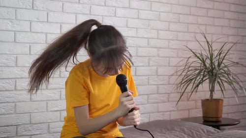 Energetic Girl Singing into Microphone at Home