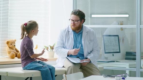 Pediatrician Talking with Little Girl in Clinic