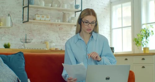 Woman Working at Home with Laptop and Headset