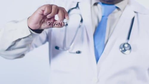 Doctor Writing 'Migraines' on Transparent Surface