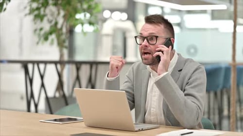 Upset Businessman Talking Angrily on his Phone