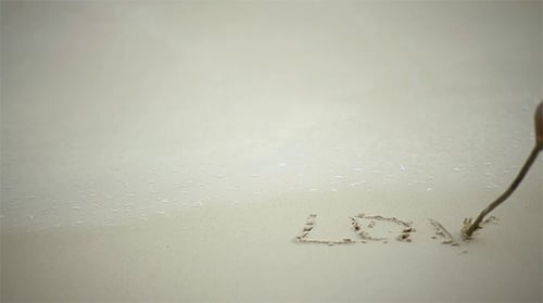 Writing Love Message in the Sand on Beach