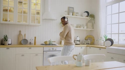 Man Dancing in Kitchen with Headphones