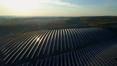 Luftaufnahmen von Drohne. Flug über Solarpanel-Farm bei Sonnenuntergang im Herbst.