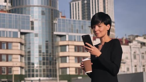 Business Woman Uses Smartphone in Urban Setting