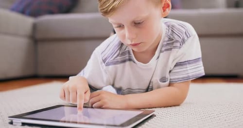 Child Using Tablet While Lying on Carpet