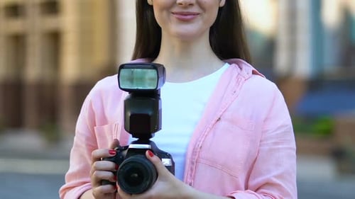 Young Woman with Camera in City Setting