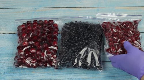 Three Bags of Frozen Berries Placed on Blue Wood