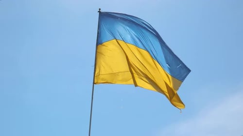 Ukrainian Flag Waving in the Breeze Under Blue Sky