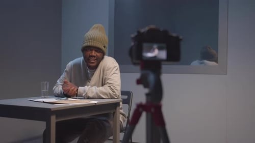 Criminal Examines Camera at Police Station