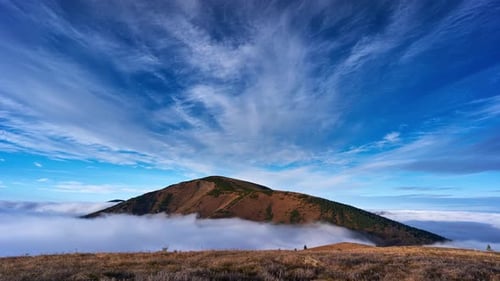 Inverse clouds moving around the top of a mountain in a national park. Zoom in