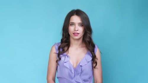 Surprised Woman Expressing Shock in Front of Blue Background