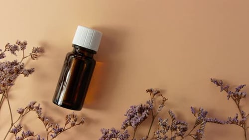 Herbal essential oil glass bottle mockup beige flowers background Spa aromatherapy beauty cosmetics