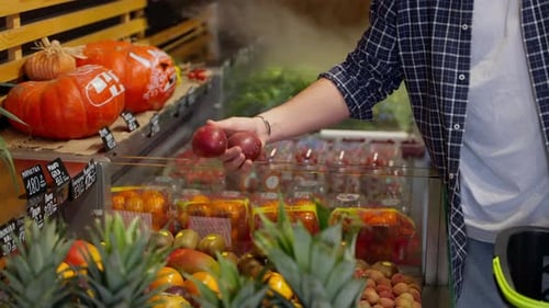 Male Customer is Choosing Passion Fruit in Grocery Shop with Organic Food and Exotic Fruits