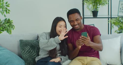 Young Adults Video Calling from Living Room Sofa