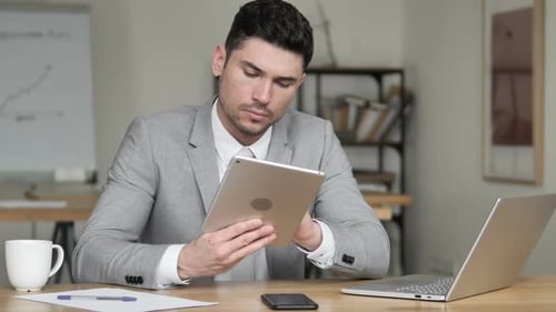 Businessman Using Tablet in Office