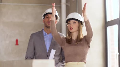 Architects with Blueprint and Helmets at Office 26