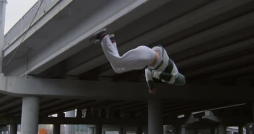 Man Performs Backflip Under Urban Overpass