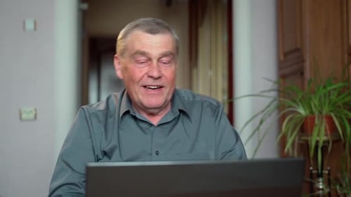 Mature Man Video Calling on Laptop from Home