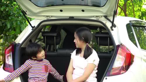 Child and Teen Sitting in Back of Car Talking