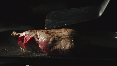 Chef kocht ein Rindersteak auf einem Grill