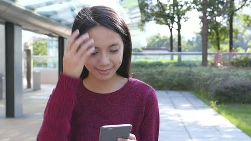 Woman Using Mobile Phone in Urban Park Setting