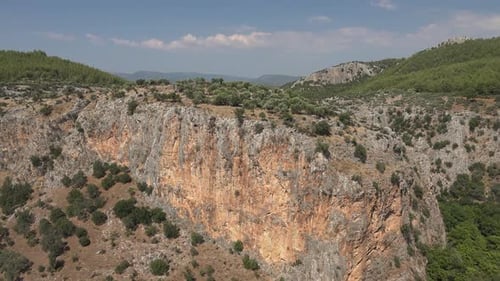 Rocky Walls and Narrow Cliff Valley in Pine Forest