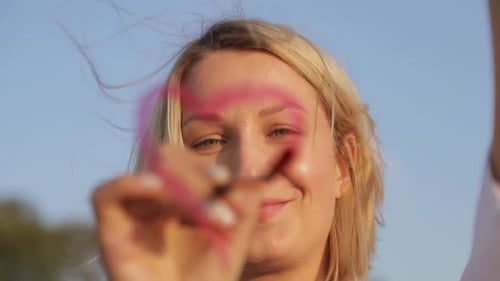 Ein junger Künstler malt ein rotes Herz auf das Glas.