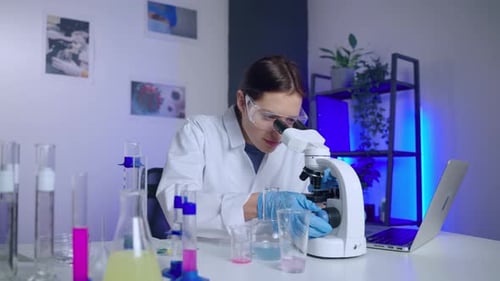 Woman Scientist Using Microscope in Lab