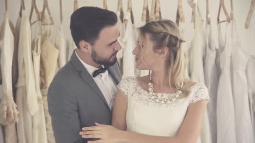 Engaged Couple Embrace in a Wedding Dress Shop