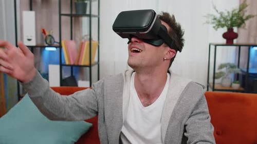 Man Using VR Headset on Sofa at Home