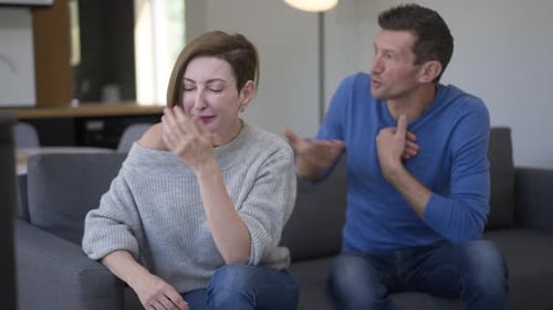 Man and Woman Arguing on Couch at Home