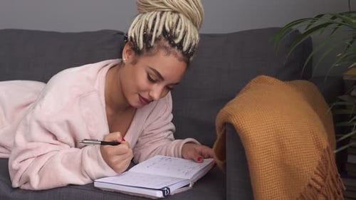 Woman Lying on Couch Planning in Calendar