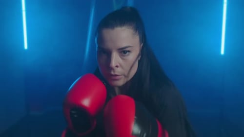 Woman Boxing in Blue Neon Lit Gym