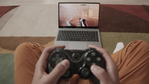 Engrossed Gamer Playing Video Game on Laptop