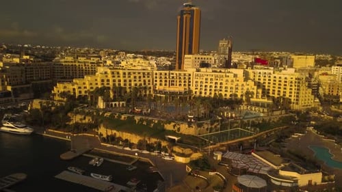 Aerial view of San Giljan, Malta at sunrise as the morning light makes the whole city glow with a go