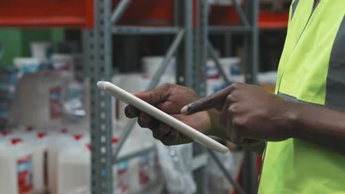 Mains d'un employé d'entrepôt afro-américain utilisant une tablette