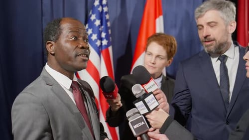 Official Giving Press Conference to Journalists with Microphones