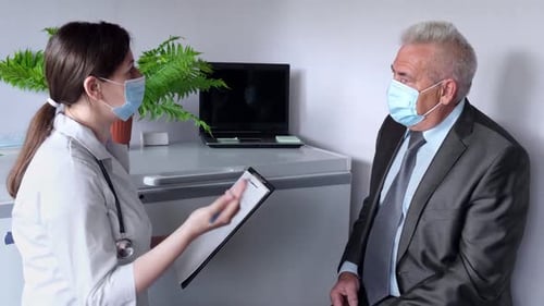 Doctor Consulting with Senior Patient in Medical Office