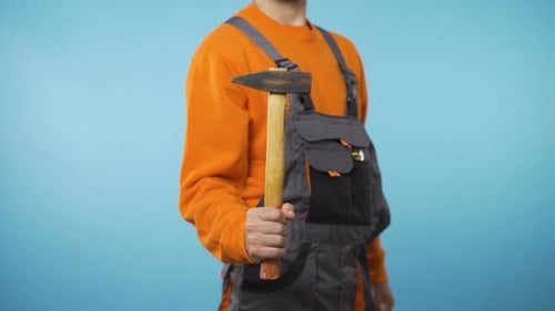 Unrecognizable Repairman Holding a Hammer in One Had