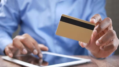 Man Shopping Online Using Tablet and Credit Card