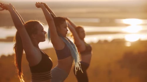 Women Practicing Yoga at Sunrise