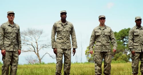 Four Men in Military Uniform Standing in Field