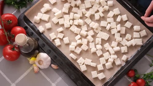 Faire des croûtons de salade César en tranches de pain grillé sur une plaque de cuisson