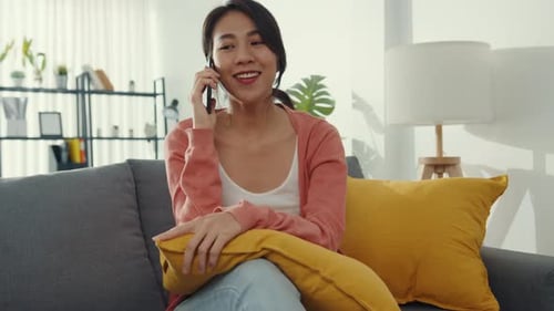 Woman Chatting on Cellphone on a Couch