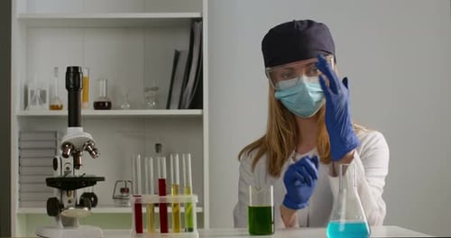 L'employé de laboratoire met des gants de protection. Expériences en laboratoire. Recherchez un