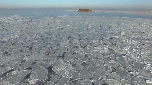 Winter Frozen Sea Captured From a Drone Fishermen Sit on Ice and Fishing